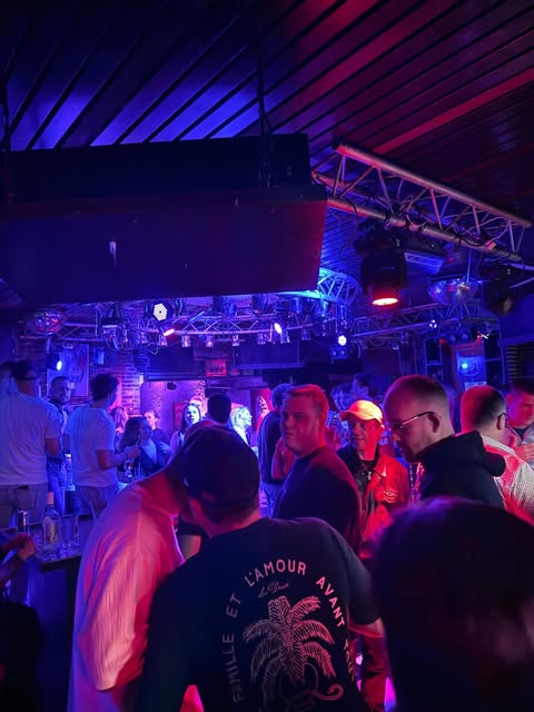 Feestgangers dansen tussen blauwe en paarse lichten